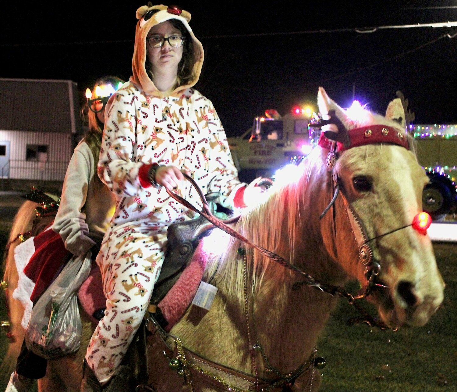 Jetta the red-nosed "reinhorse" gave Ashley Ledbetter, at the reins, and passenger Graycie Tackitt a lift at the Willow Springs Christmas Parade. Despite heavy drizzle, the parade proceeded through downtown Willow Springs and was organized by the Willow Springs Chamber of Commerce.